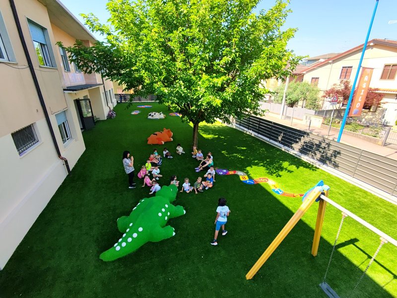 Area gioco asilo con erba sintetica antitrauma per bambini