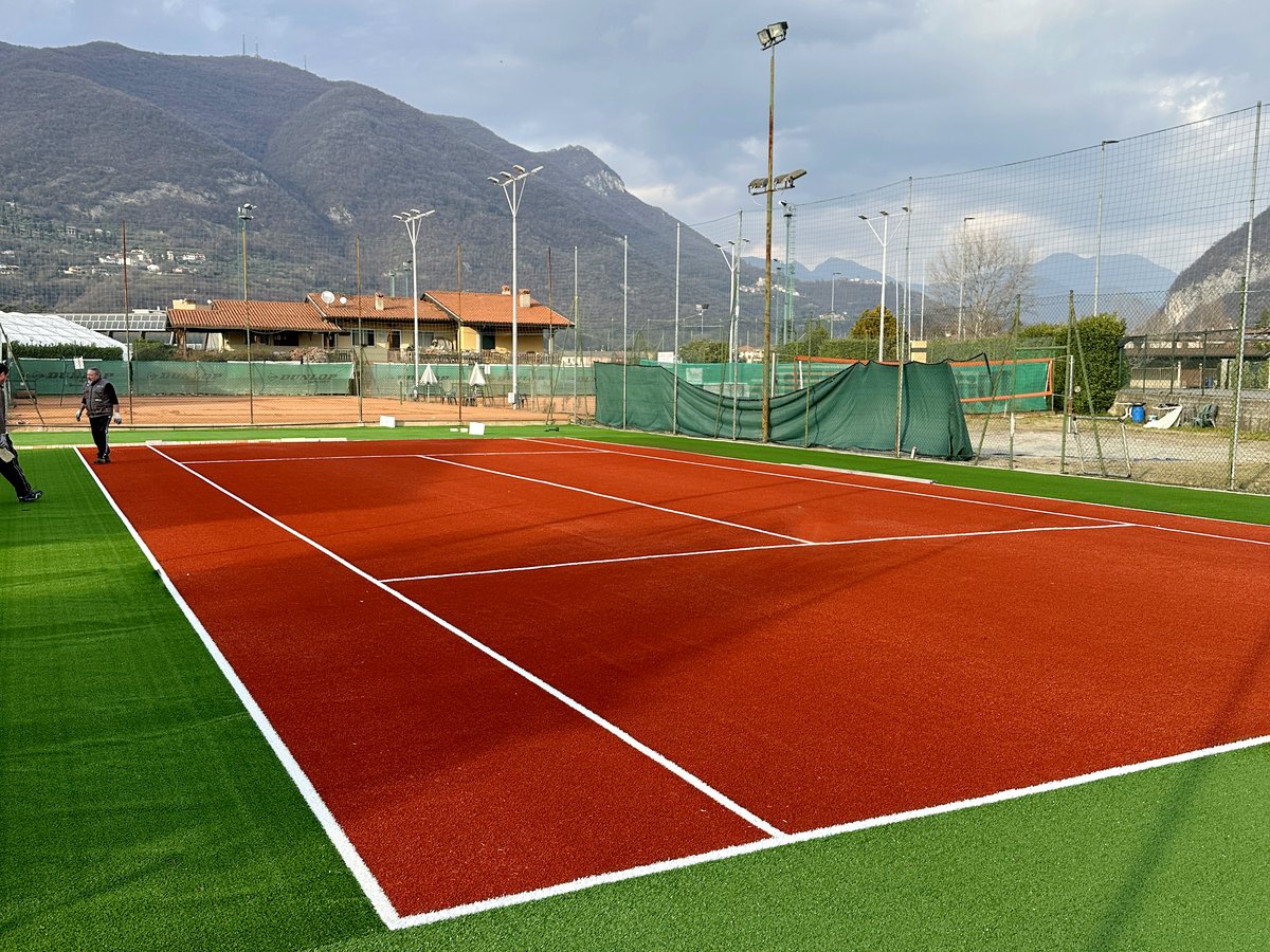 Campo da tennis in erba sintetica con vista sulle montagne